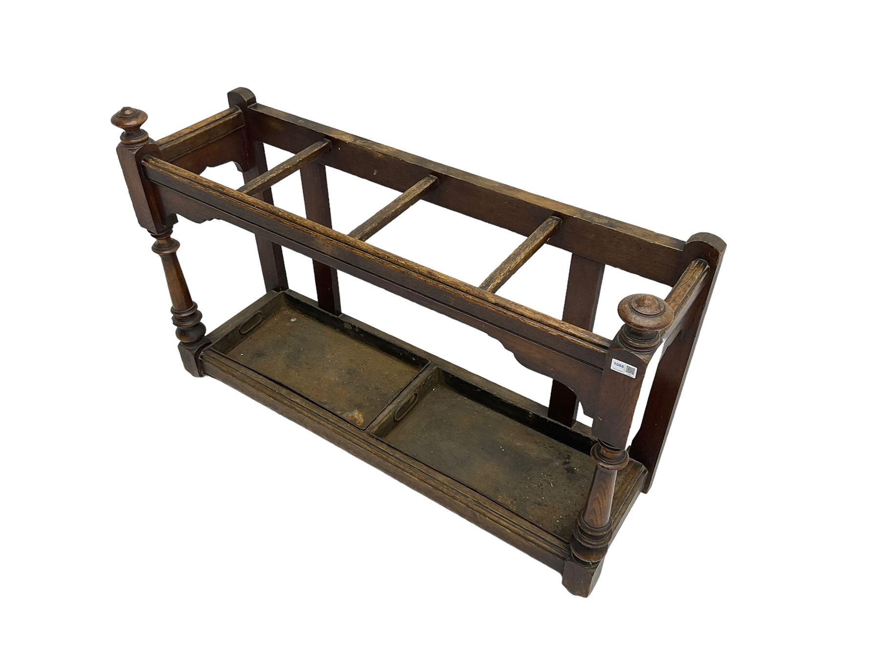 Edwardian oak hallway stick and umbrella stand, four divisions on turned supports, with metal tray liners and various sticks
