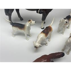 Beswick hunting group, comprising huntswoman on grey horse no 1730, huntsman on brown horse no 1501, fox figure no 1440 and eight fox hounds, all with printed marks beneath (11)
