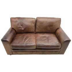 Two-seat sofa, traditional shape with rolled arms, upholstered in distressed brown leather, on turned feet; together with small footstool