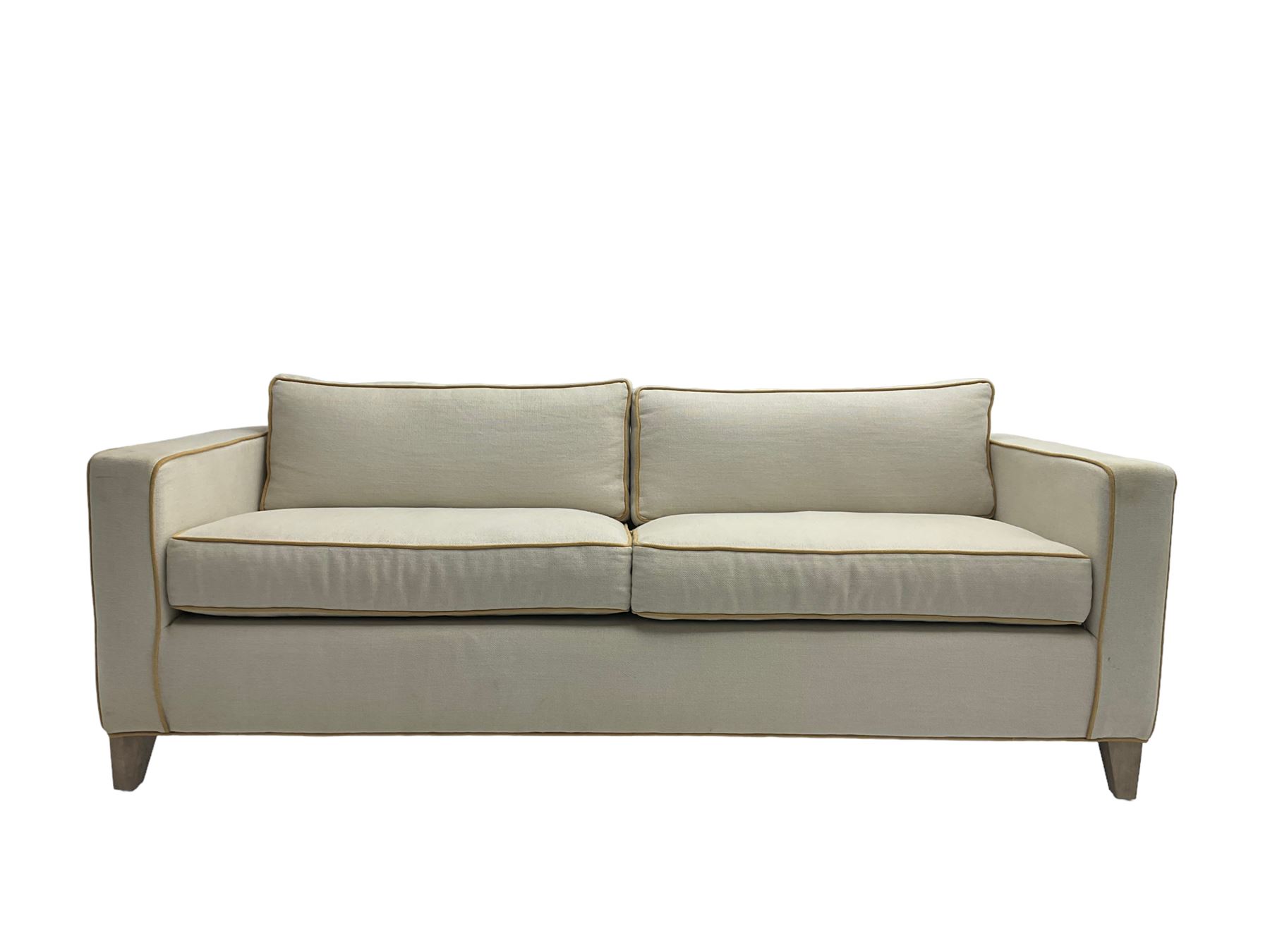 Neptune - pair three seat 'Shoreditch' sofas,  upholstered in cream fabric with yellow stringing