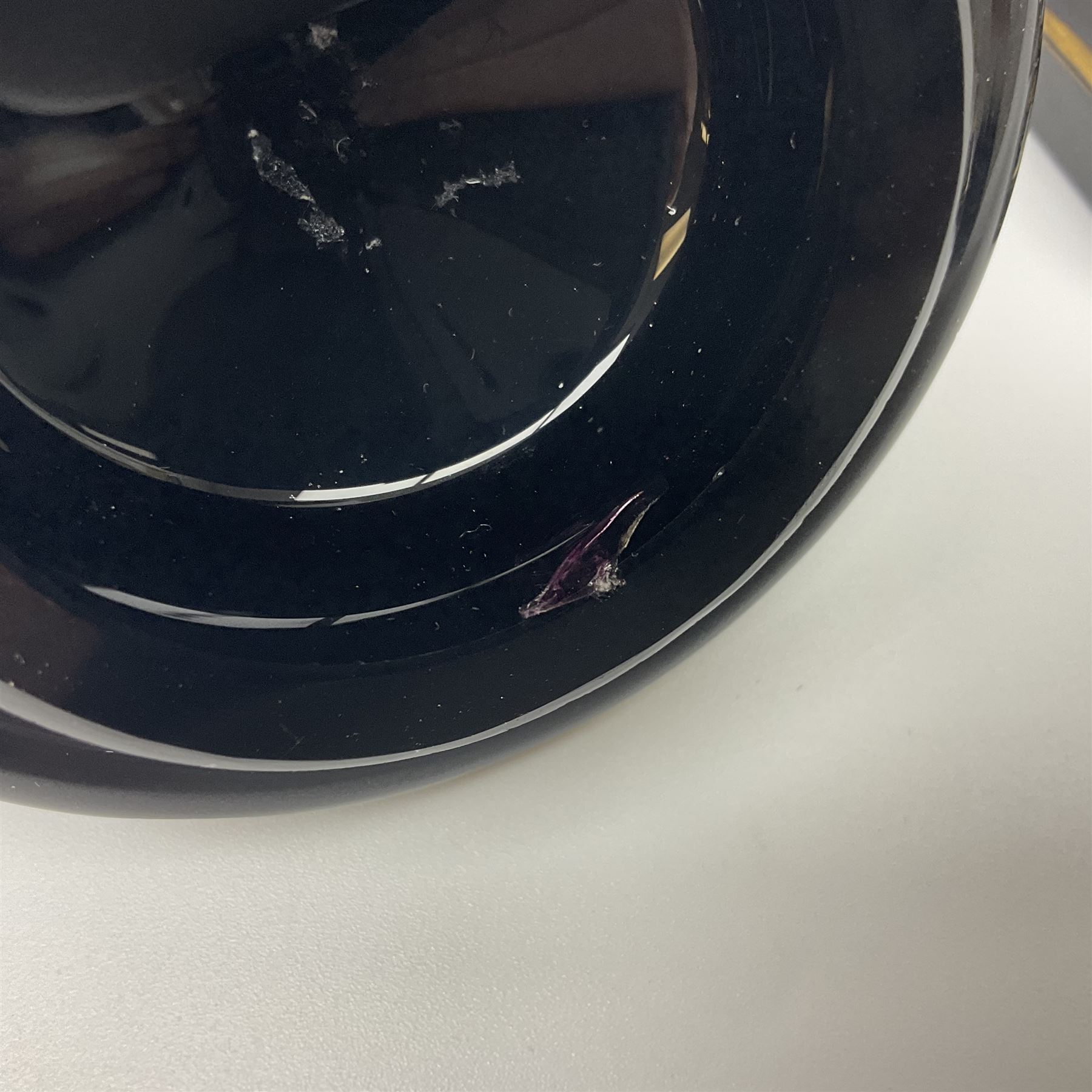 19th Century Bohemian amethyst glass lidded goblet, the bowl of faceted form, gilded with three children in period dress playing games, upon a knopped stem and conforming faceted foot, together with an art nouveau green glass goblet, with gilded rim, upon clear trumpet stem, and a hand blown wine glass, transfer printed with birds and three figures in period dress, tallest H29cm