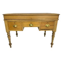 Early 20th century light oak kneehole desk, rectangular hinged top, fitted with frieze drawer flanked by two deep drawers, raised on ring turned supports