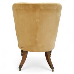 William IV mahogany library armchair, beige velvet upholstered back and padded seat with piping and scroll carved arms, reeded uprights, raised on tapered reeded front legs and out-swept back legs with brass castors 
