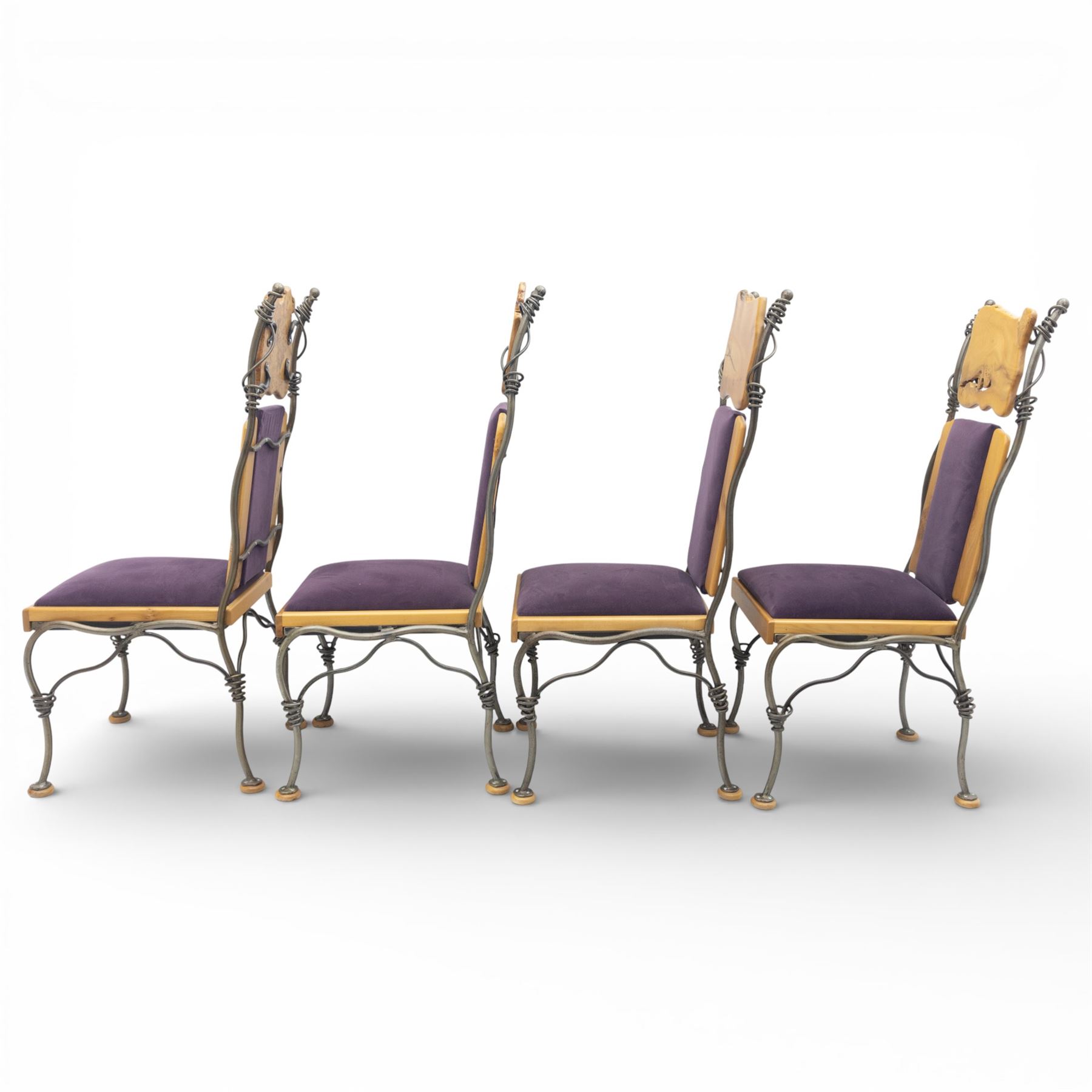 Paul Hodgkiss Designs of Glasgow - contemporary shaped elm dining table with wrought iron base; with set ten (8+2) matching high-back dining chairs, table of organic form above an elaborate wrought iron supports, with central elm stretcher, the chairs with en suite with matching wrought iron work burred elm headrest, purple velour upholstery with drop in seat     

Table: W 102cm, L 243cm, H 74cm
Chairs: W 56cm, D 52cm, H 130cm