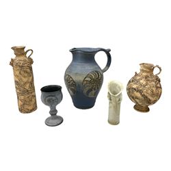 Group of studio pottery to include a large jug decorated with stylised ammonites upon a blue ground, signed indistinctly beneath, together with a goblet cup similarly decorated, vase of cylindrical vase signed JSH beneath, and two further ewers of cylindrical and spherical form both with textured decoration and handles, largest H30cm