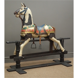  Late 20th century black and white painted rocking horse, bridle and stirrups, ebonised trestle base, L130cm, H117cm  