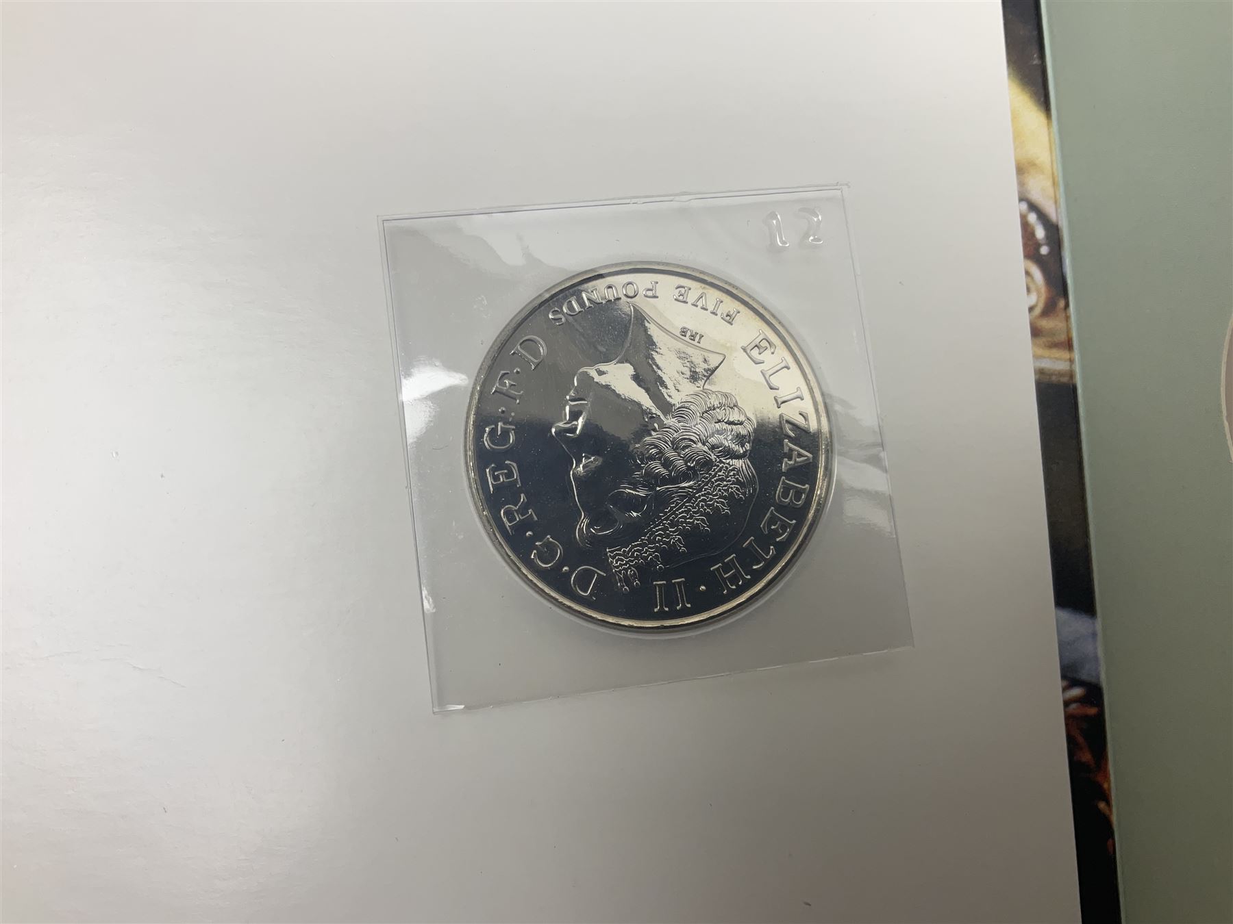 Seven Queen Elizabeth II United Kingdom five pound coins, including 2006 and 2007 in card folders, etc. 