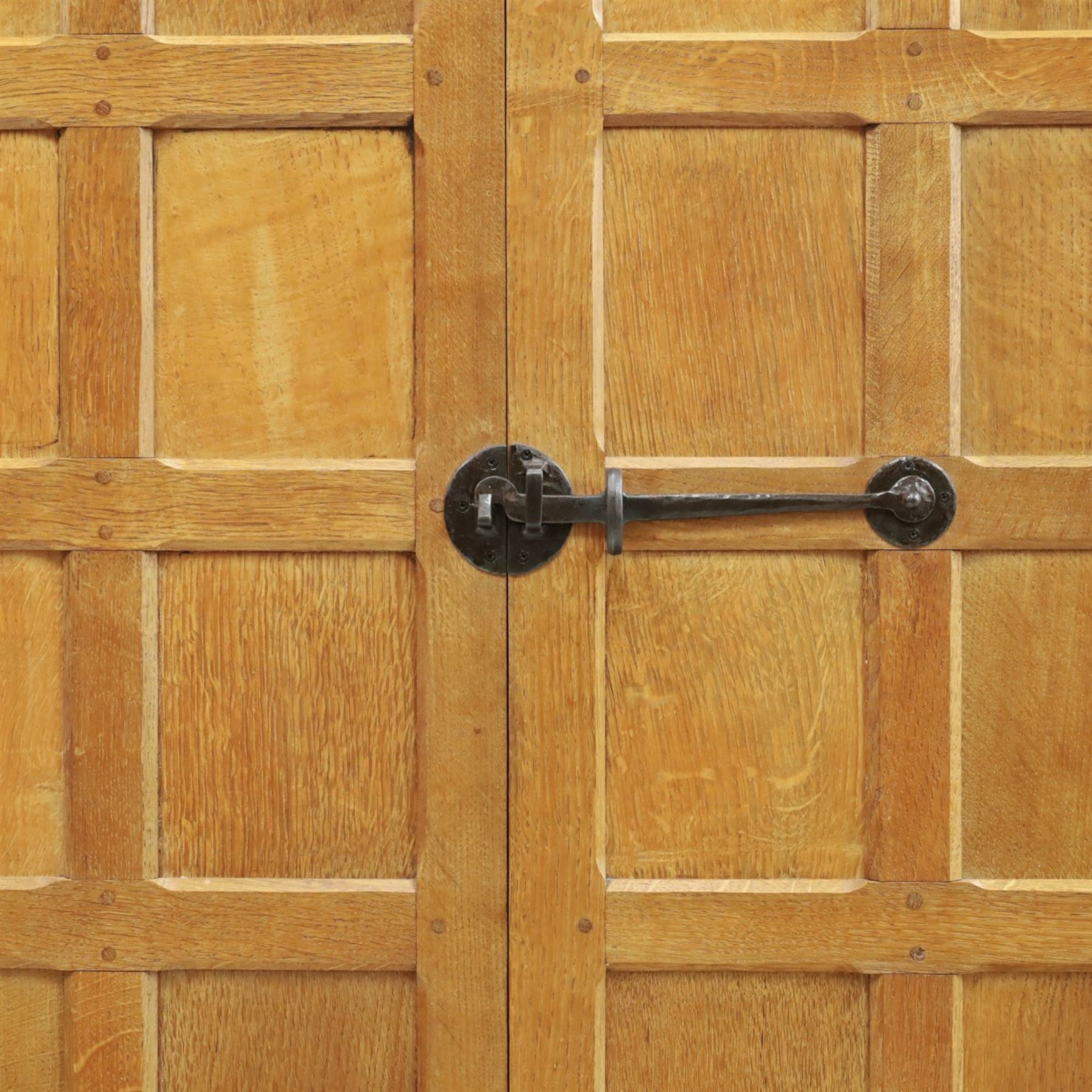 Mouseman - early-to-mid-20th century panelled and adzed double wardrobe, the arcade carved cresting rail over two panelled doors, with wrought metal hinges and latch, deep relief carved mouse signature, the interior fitted with hanging rail, by the workshop of Robert Thompson of Kilburn