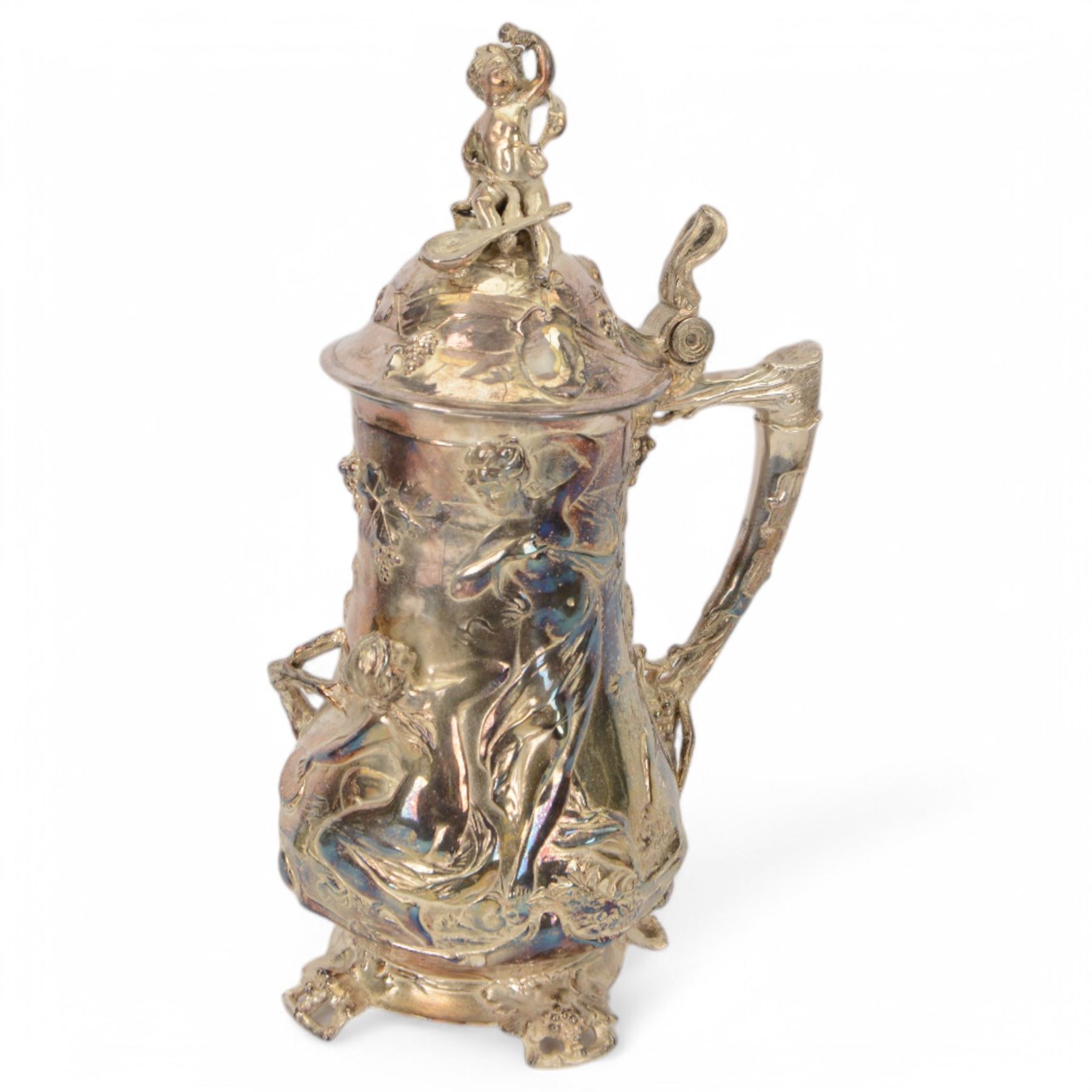 Large late 19th/early 20th century WMF Art Nouveau silver plated stein or jug, circa 1900, the bellied body cast and applied with Bacchanalian figures, the domed cover with putti finial, and handle modelled as a vine, the whole upon four fruit and leaf mounted feet, marked beneath for WMF and engraved with initials CHE and dated 1911, H40.5cm

