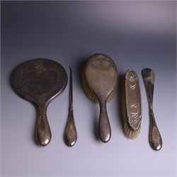 Early 20th Century silver mounted dressing table set, comprising hand mirror, shoe horn and a button hook, each with engraved floral decoration, together with a silver mounted hairbrush and clothes brush, all hallmarked