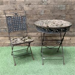 Circular metal garden table with tile top and matching chair, weathered