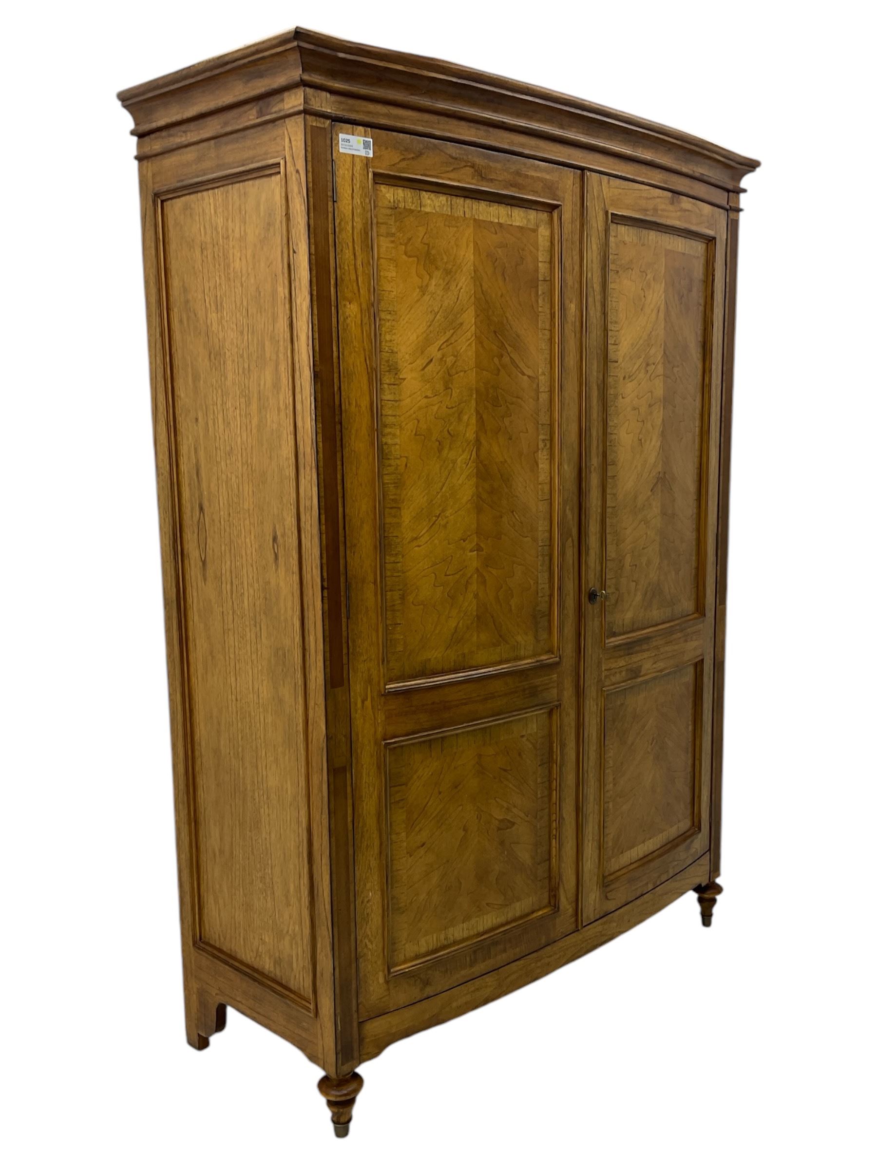 Frank Hudson - mid-20th century Mindi ash and burr walnut double wardrobe, moulded rectangular cornice over two panelled doors with chevron pattern veneers, raised on turned supports