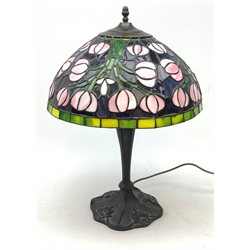A Tiffany style table lamp, with cast spreading base detailed with flowers, and leaded glass shade, overall H53cm.