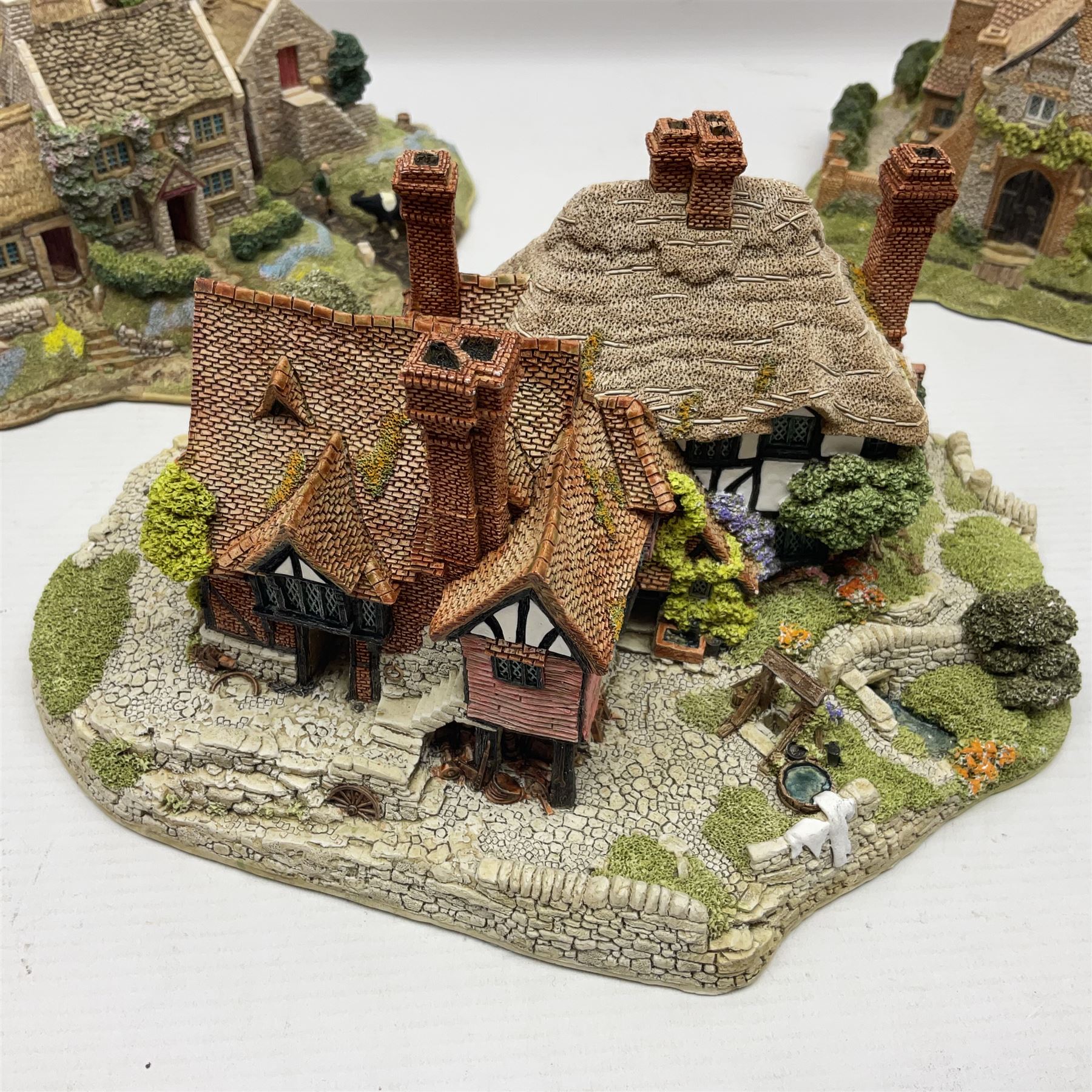 Three Lilliput lanes, comprising Oakwood Smithy, Anne of Cleves and Bluebell Farm, all with deeds and original boxes 