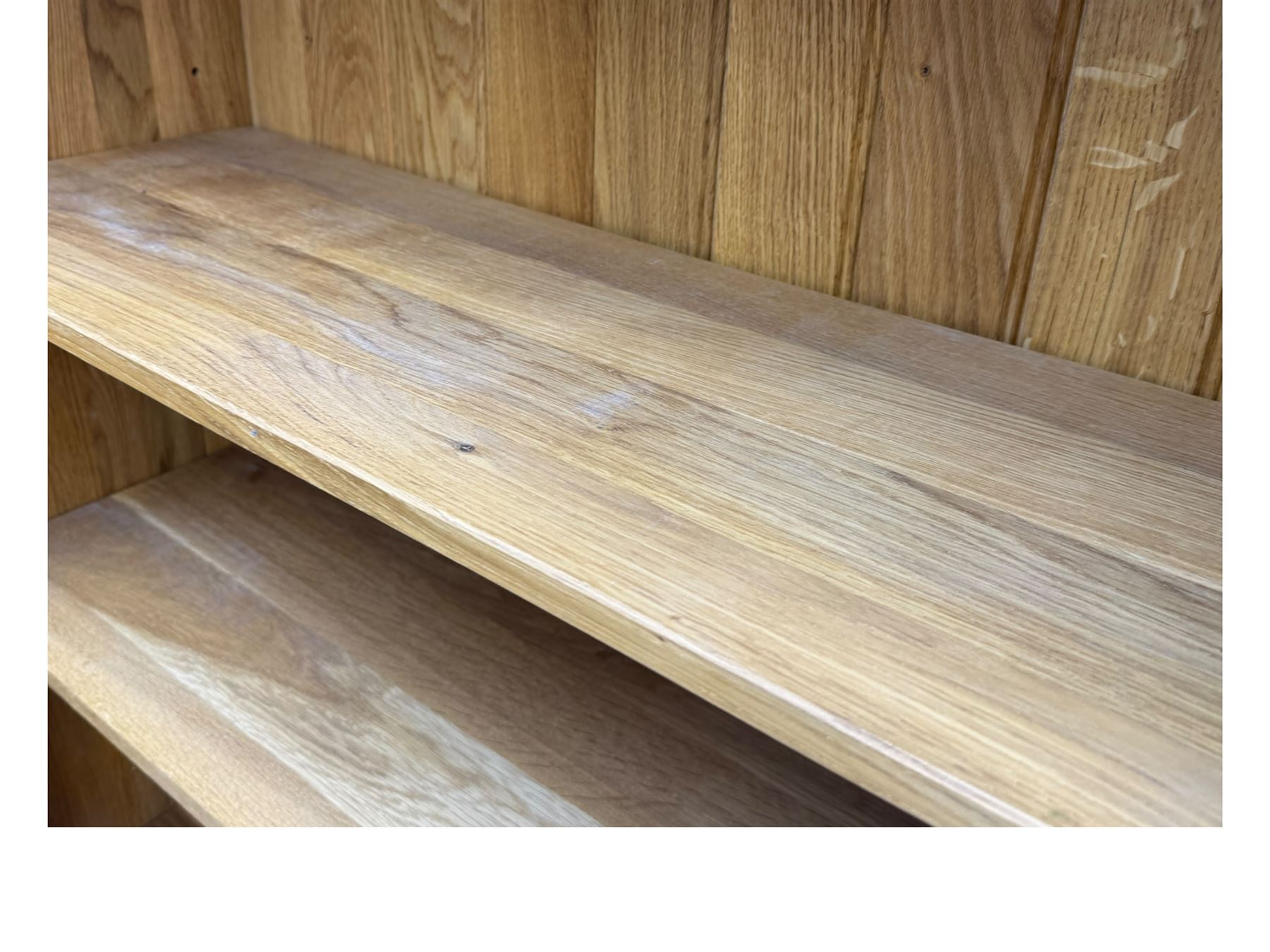 Contemporary light oak open bookcase, rectangular form with projecting top, fitted with five adjustable shelves, on a straight plinth base