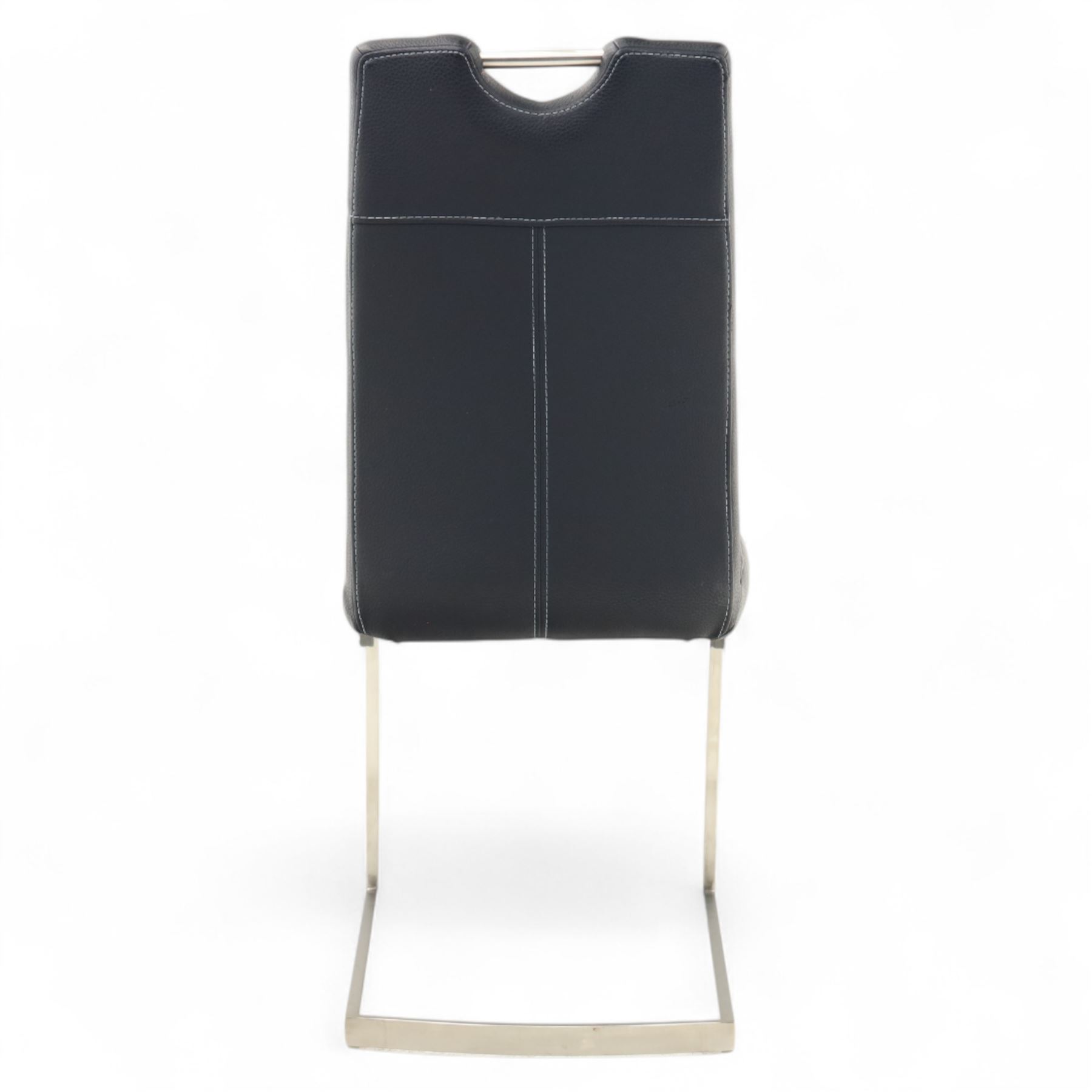 Set of seven contemporary style dining chairs, each with a high padded back and seat upholstered in faux leather on brushed steel sled bases  