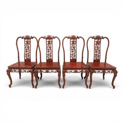20th century Chinese ornately hardwood dining table and chairs, circular table with 'Lazy Susan' top with pierced carved frieze, raised on a quadriform base with carved foliate detail, the chairs en suite with carved pierced detailing  