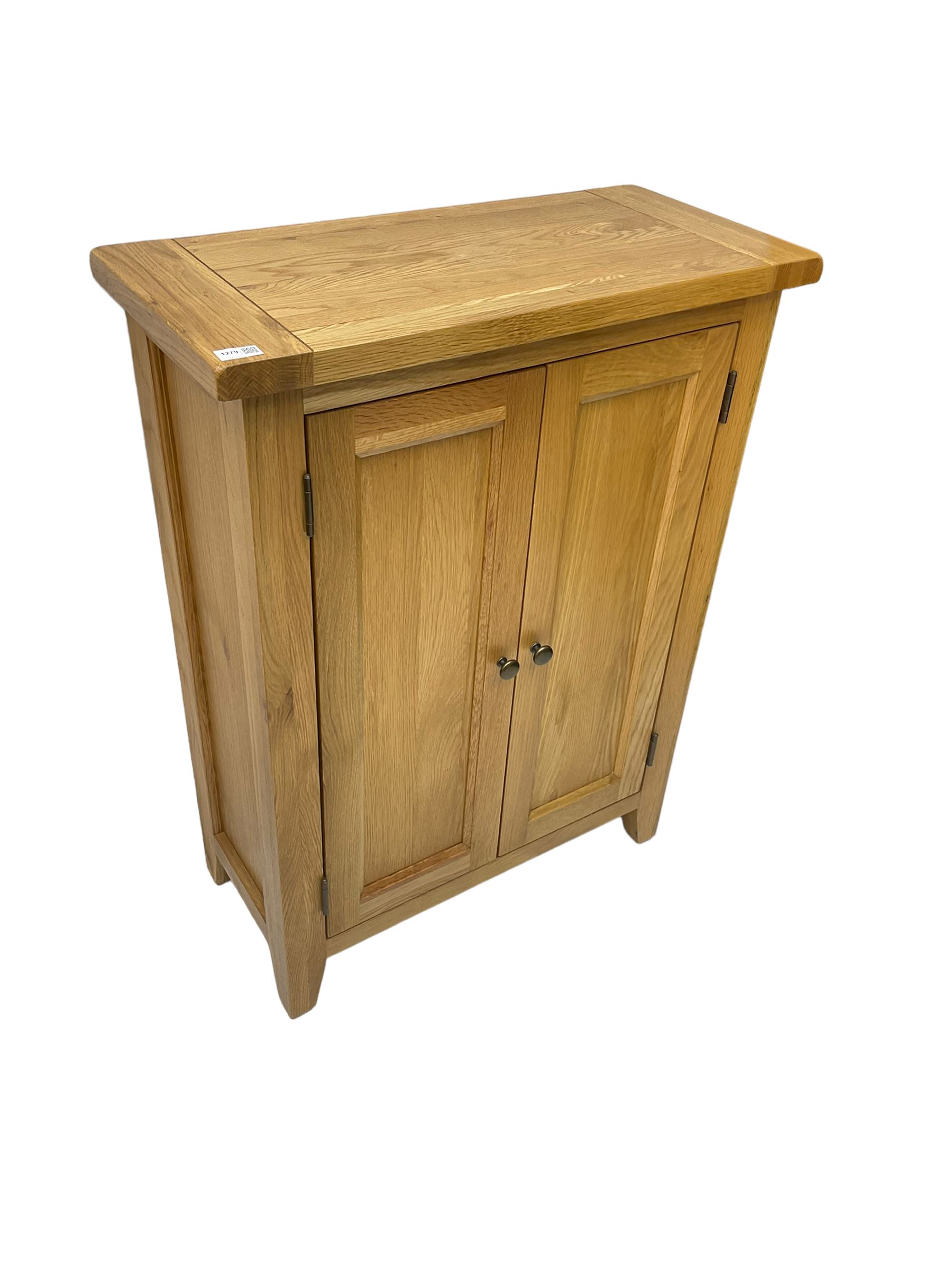 Solid light oak cupboard, fitted with two panelled doors enclosing two shelves, on tapered feet