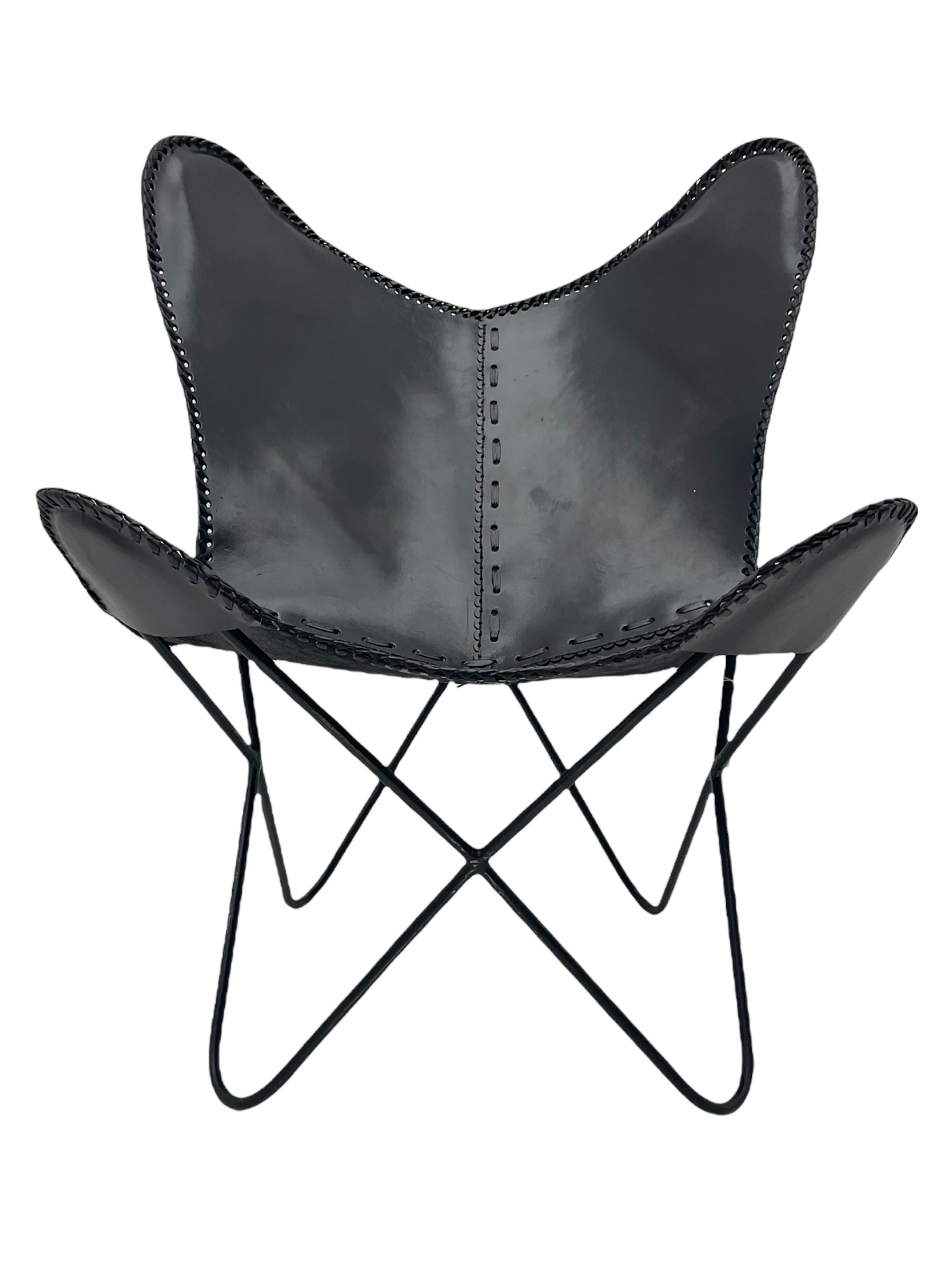 Metal framed butterfly chair upholstered in slung dark tan stitched leather 
