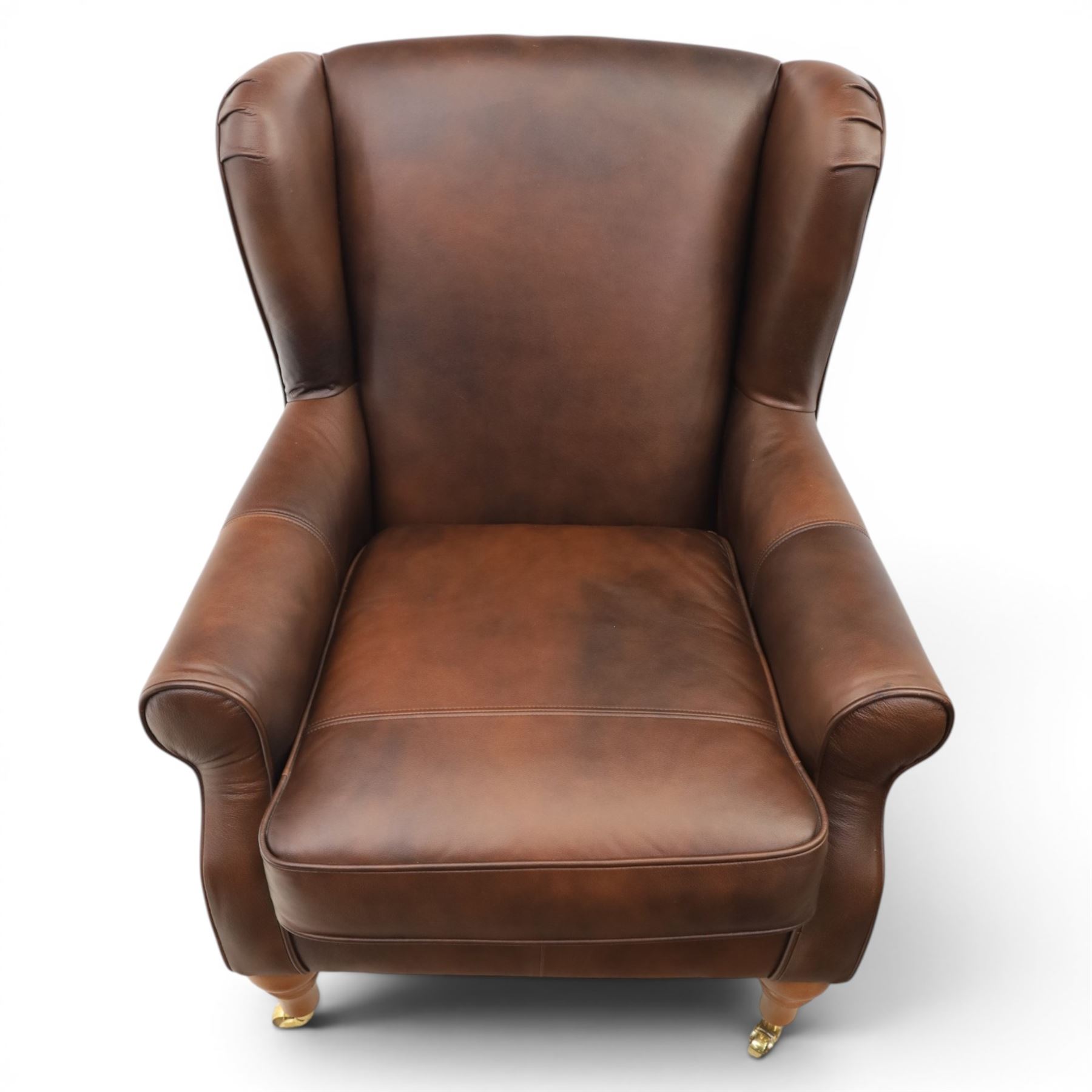 Marks & Spencer - Pair of brown leather wing back chairs, raised on light stained supports with castors