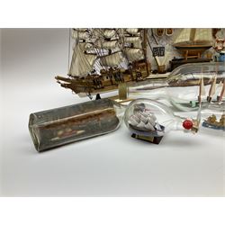Seven ships in bottles, to include Wavertree sailing ship, a three masted ship and a tugboat, together with small scale model ship with a plaque 'H.M.S Agamemnon', another model ship with plaque 'Hannah', and a diorama of a ship workshop