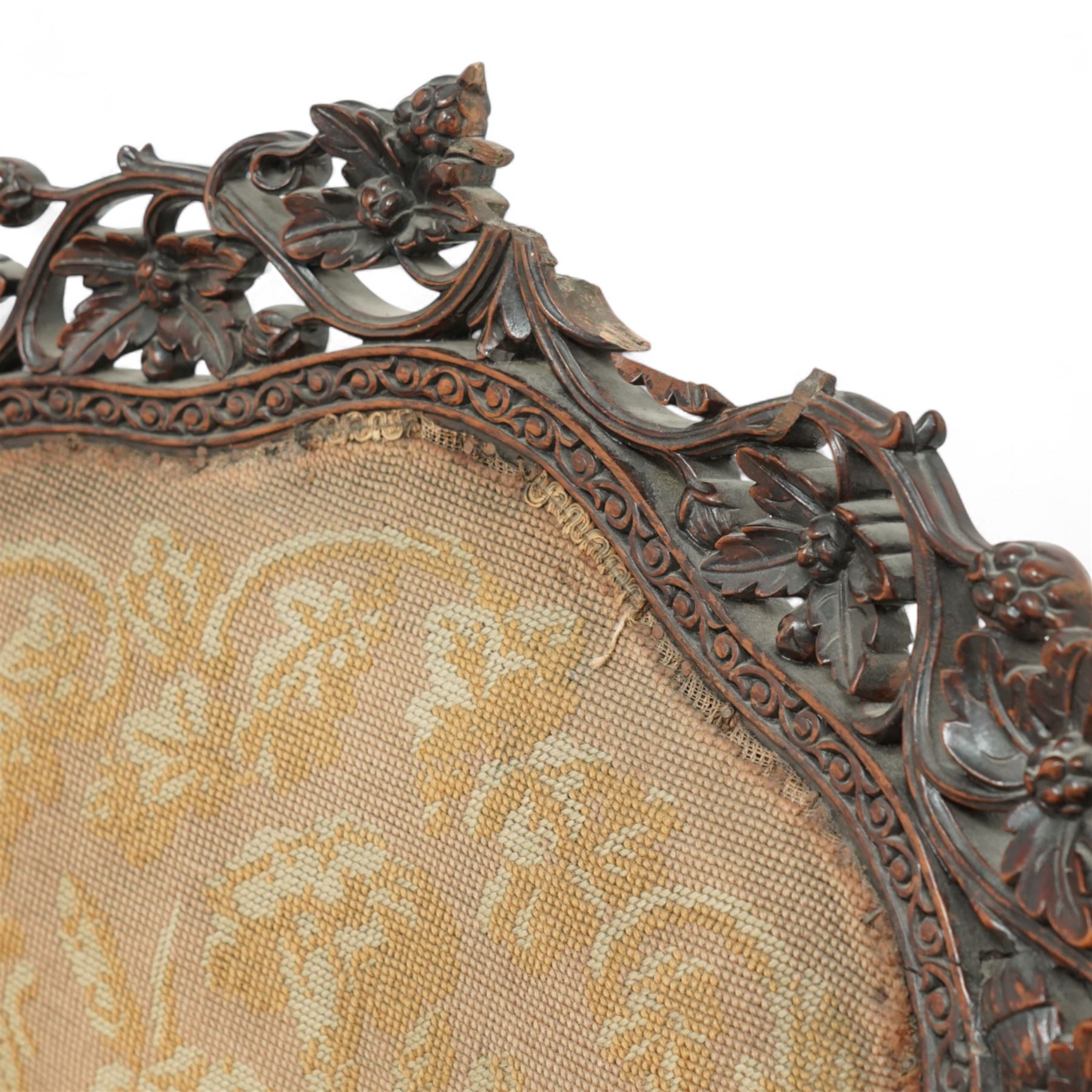 Late 19th century Anglo-Indian carved hardwood nursing chair, cartouche-shaped back, pierced fruit vine carved frame, gros-point tapestry upholstered seat, on carved scroll legs 