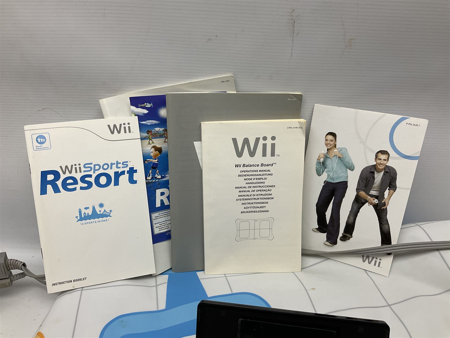 Nintendo Wii console, four controllers with cases and four nunchucks, Wii sensor bar, balance board and dance mat. Guitar hero wireless guitar for Wii and Redoctane wired guitar. Nintendo DS lite handheld gaming console, console and game cases and Guitar Hero Redoctane Guitar Grip. Selection of Nintendo Wii and Nintendo DS lite games to include Super Mario Galaxy, Guitar Hero, Wii Fit, Legend of Zelda games etc. Archos AV400 Series pocket video recorder with accessories, cradle and remote, in three boxes