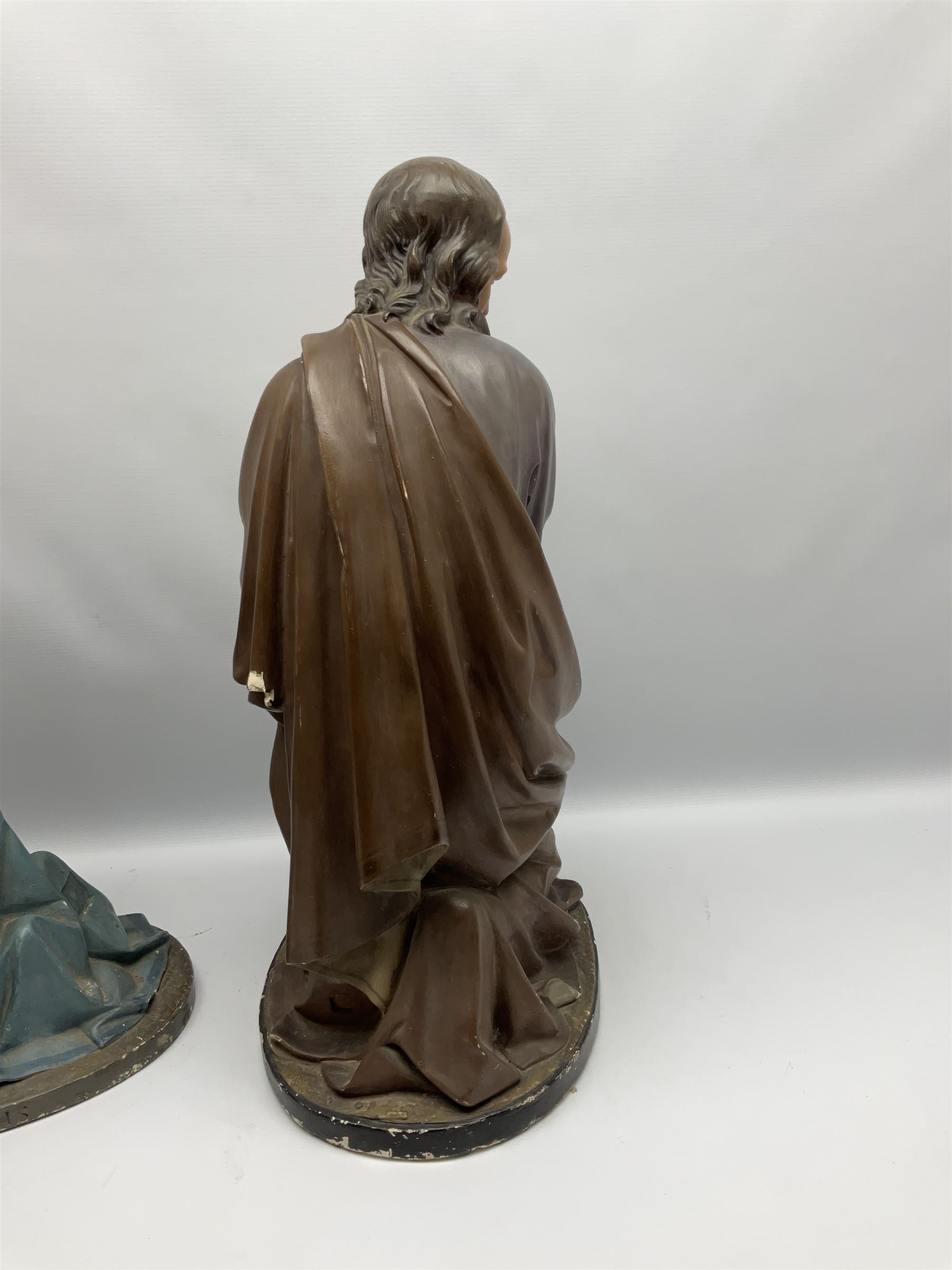 Two religious painted plaster figures of Mary and Joseph kneeling on oval plinths, with impressed mark 'Raffl et Cie Paris', H60cm 