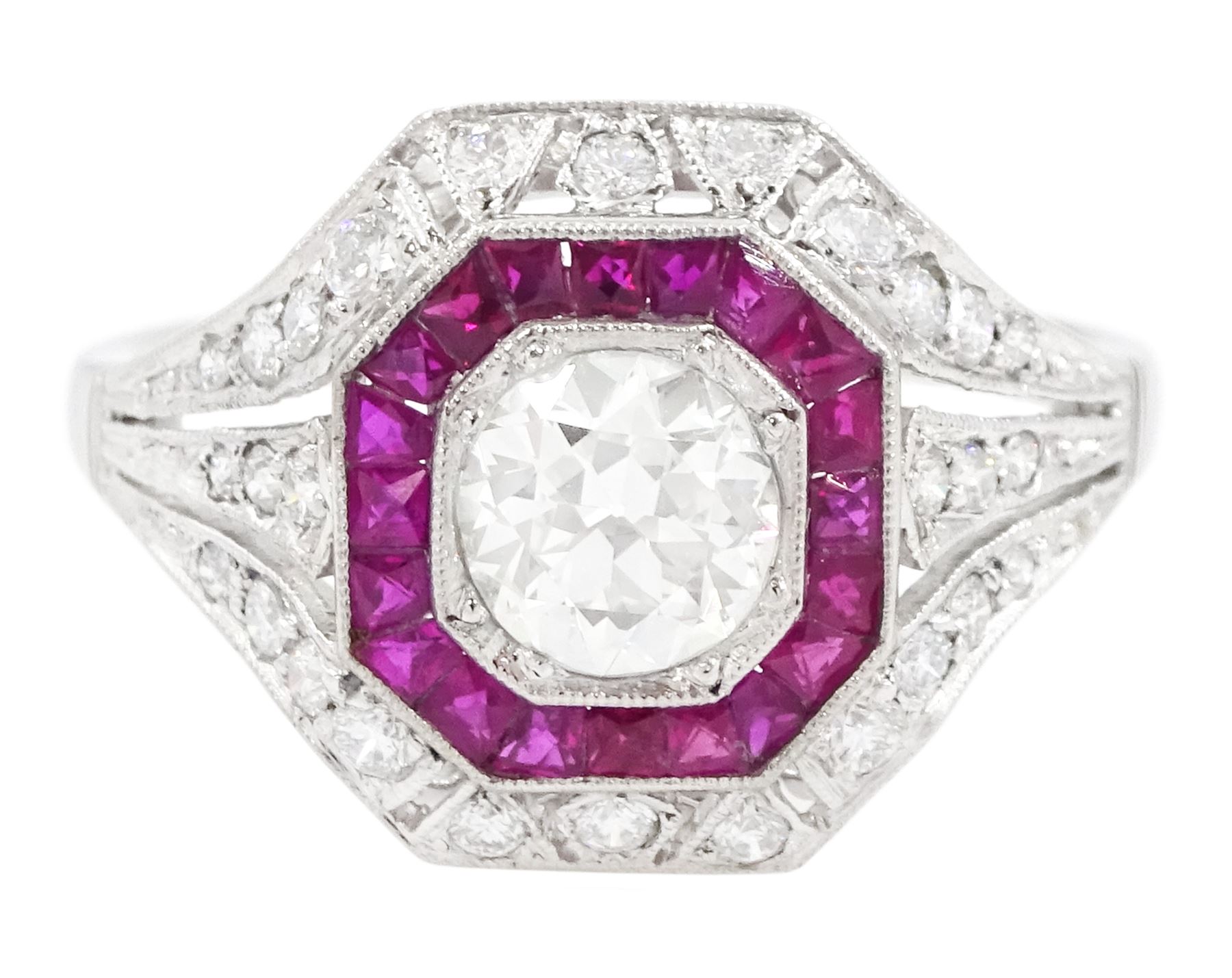 Platinum diamond and ruby cluster ring, the principal transitional cut diamond of approx 0.65 carat, in an octagonal milgrain setting, surrounded by calibre cut rubies, to further round brilliant cut diamonds and a split design shoulders