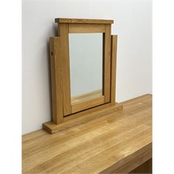 Light oak dressing table with mirror, six graduating drawers, raised on stile supports 