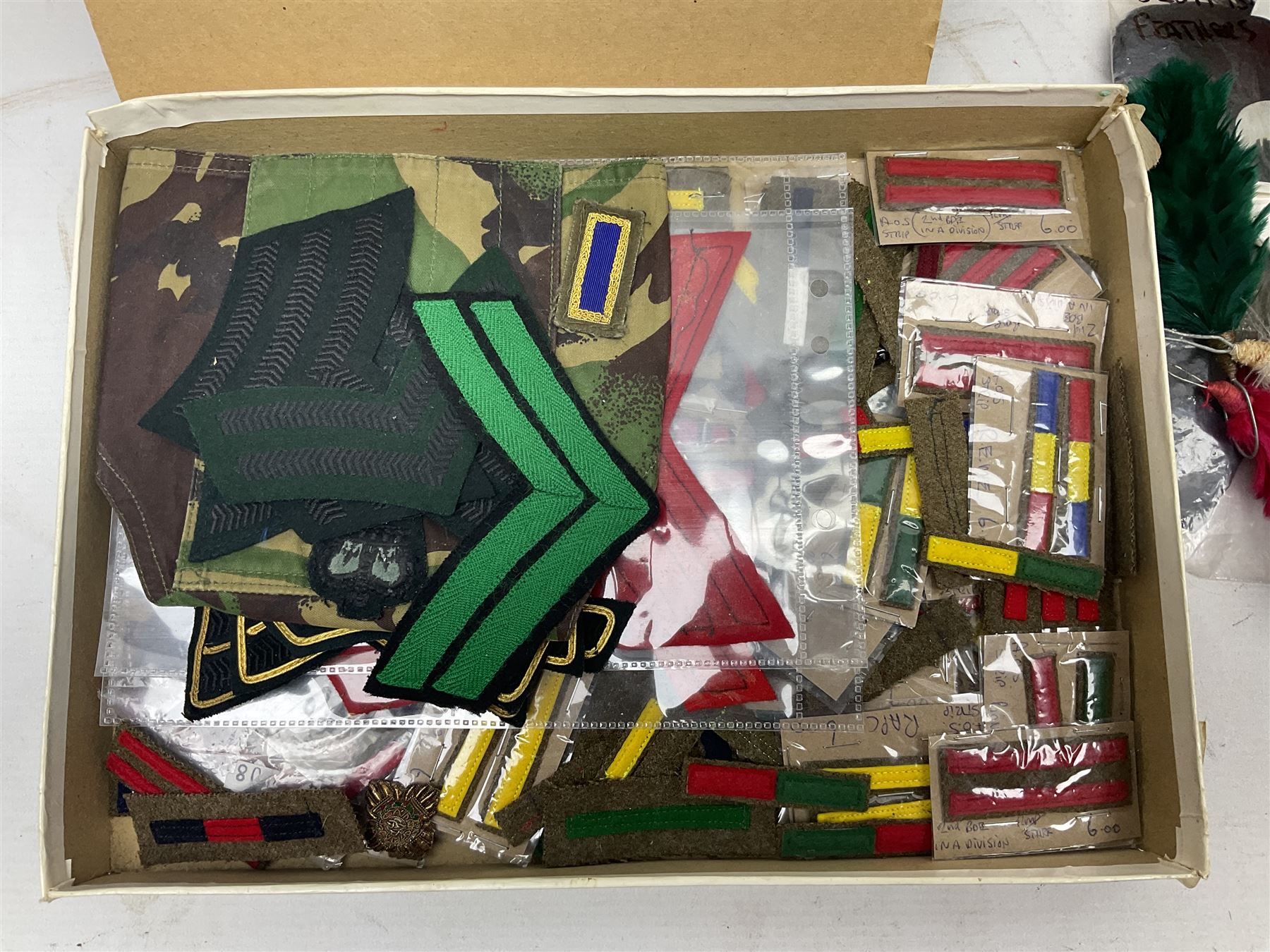 Quantity of military horse hair plumes and feather hackles, cloth stripes and regimental titles etc