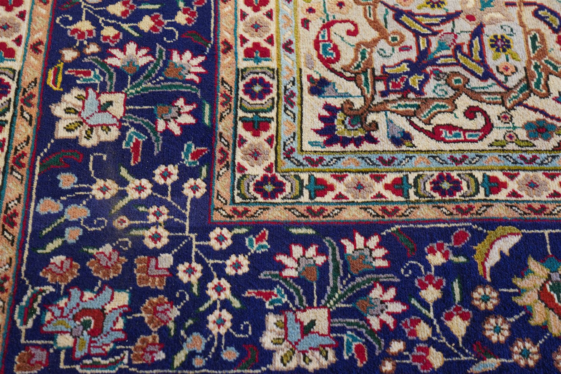 North West Persian Tabriz hand-knotted carpet, madder red field with a central cusped medallion issuing radiating pendants and an all-over design of scrolling arabesques, palmettes and flowering vinery enclosed by conforming spandrels, indigo main border of meandering floral vines and stylized palmettes, flanked by narrow guard stripes, cotton fringe ends 