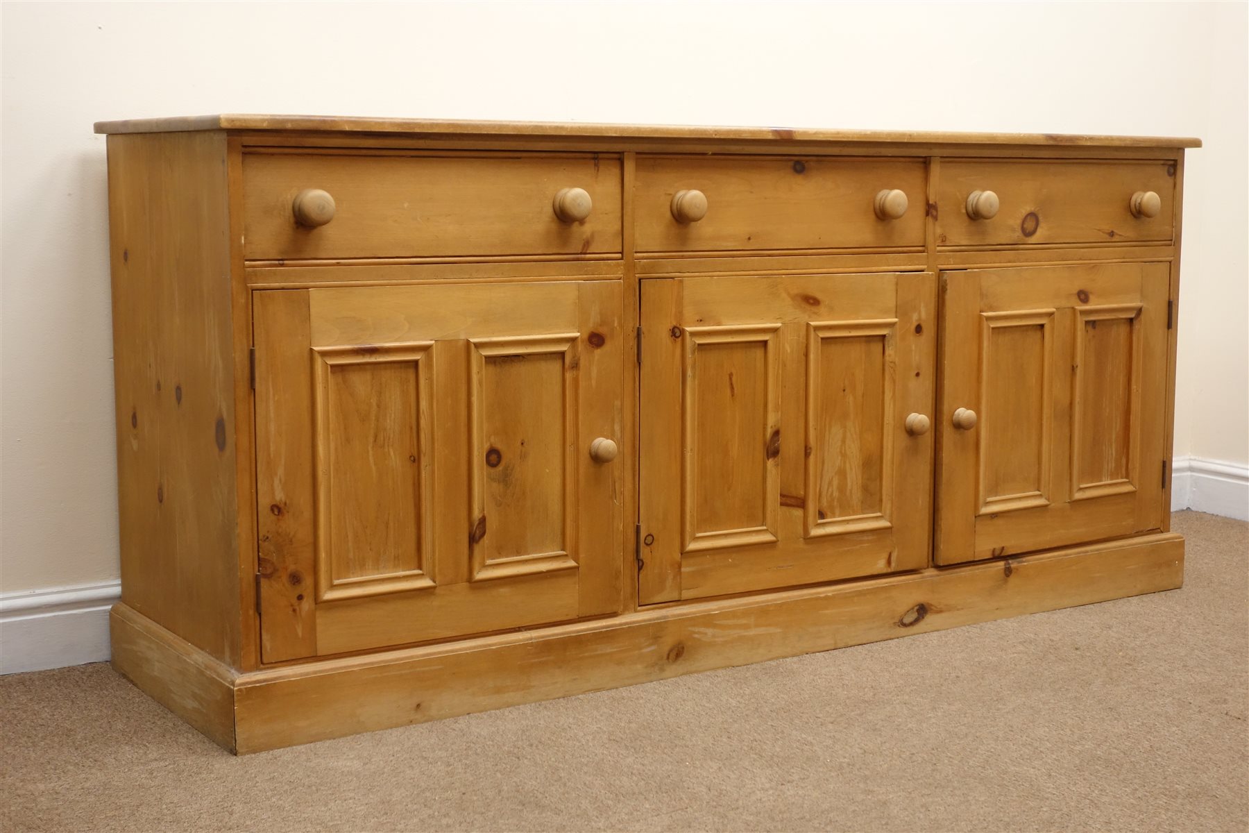 Solid pine dresser base, three drawers above three cupboards, plinth