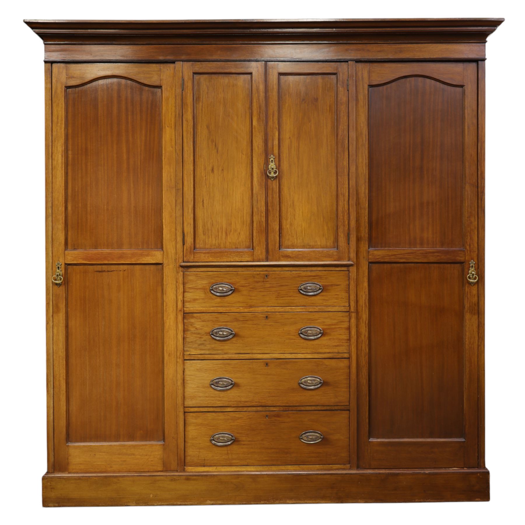 19th century mahogany triple wardrobe, moulded cornice above a central cupboard door enclosing shelves interior, flanked by full height panelled doors with clothes rails in each, the centre fitted with four graduated drawers with oval brass handles, on a moulded plinth base