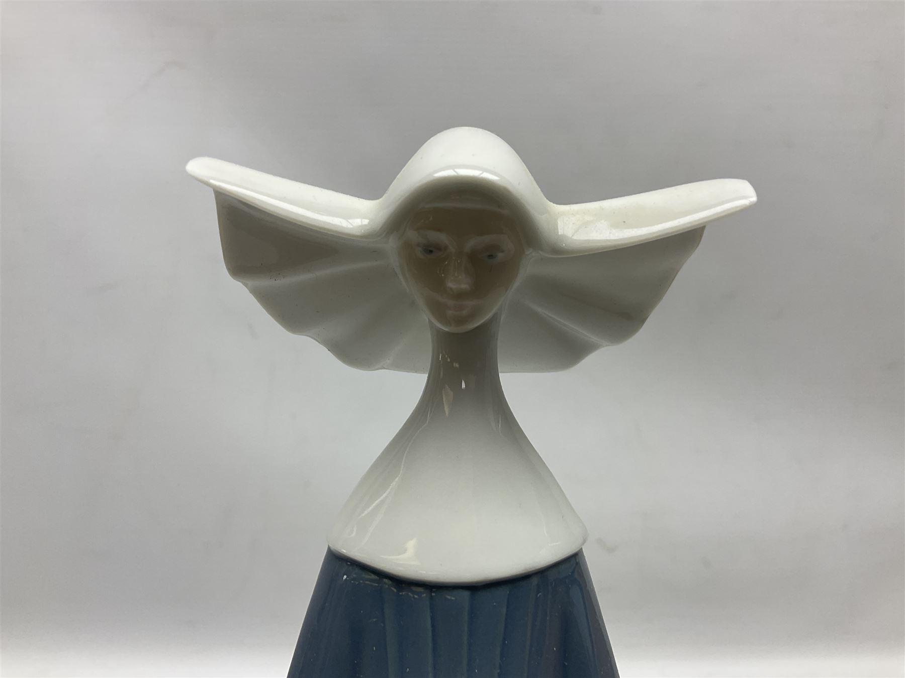 Two Lladro figures, comprising Conductor no 5196 and Prayerful Moment no 5500 together with a Lladro plaque and two Lladro candle holders, Dolphins at Play no 17666 and Sailing the Seas no 17665, all with original boxes, largest example H33cm 