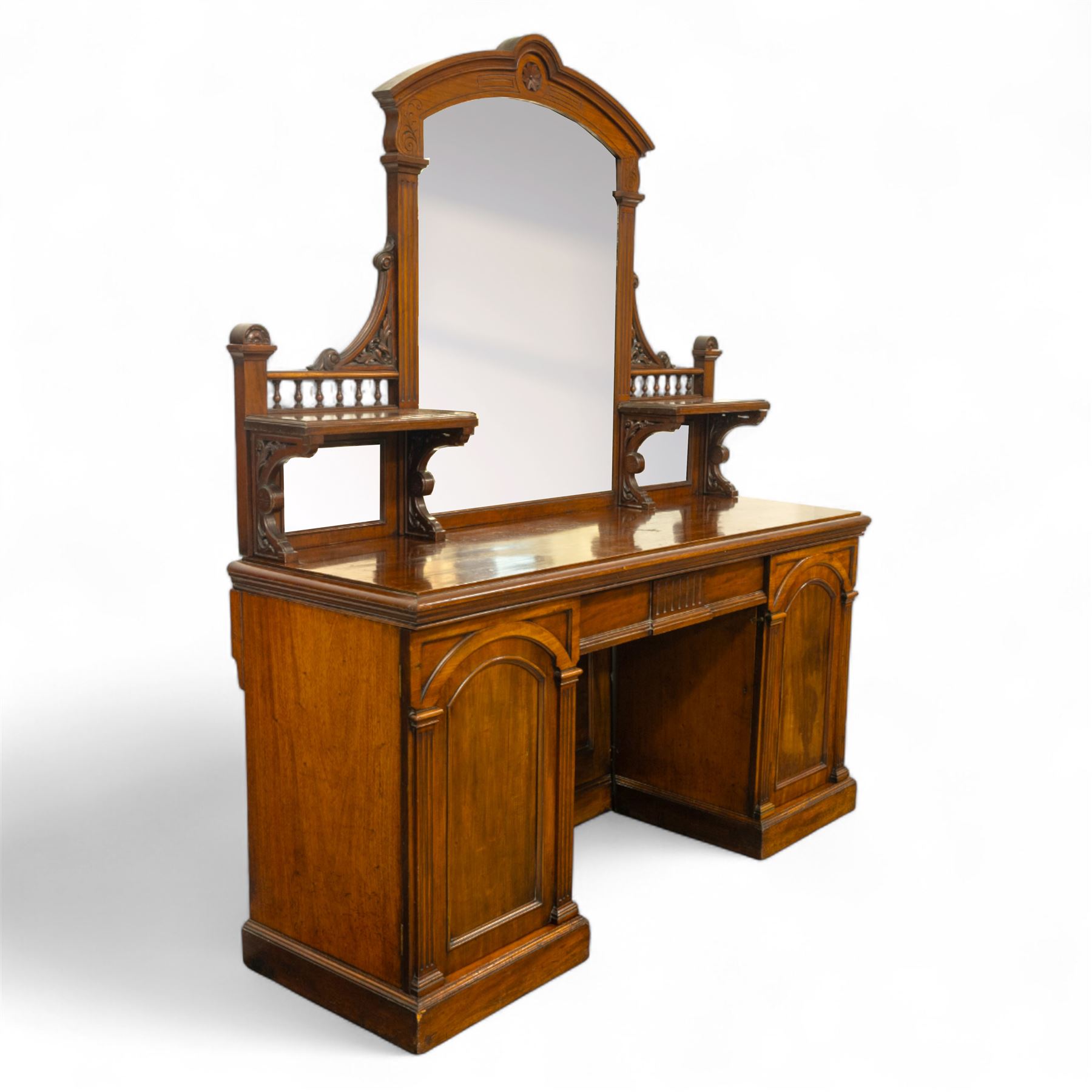 Late 19th century mahogany twin pedestal mirror back chiffonier, stamped James Winter of London, the arched mirrored back flanked by turned gallery shelves above a rectangular top, the base fitted with a pair of arched panelled cupboard doors, on a plinth base