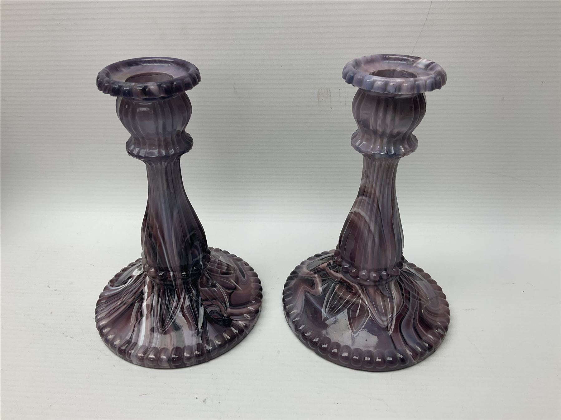 Daum glass two stemmed candle stick signed to verso, together with a pair of slag glass purple candle sticks, Daum H21cm