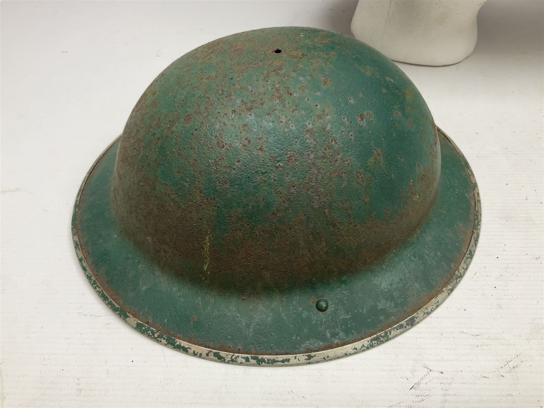 Three battlefield relic helmet shells - WWI German M16; WWI French Adrian; and WWII British (3)