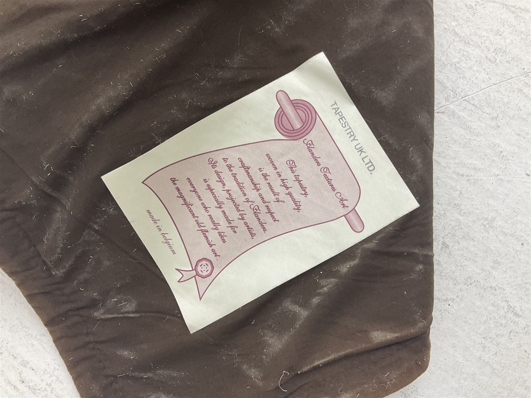 Three tapestries comprising 20th century wool tapestry panel of a medieval nobleman upon a horse with a castle in the distance, together with a smaller tapestry depicting The English Coat of Arms, both hung on rails, and further depicting village scene, largest approx 132cm x 95cm