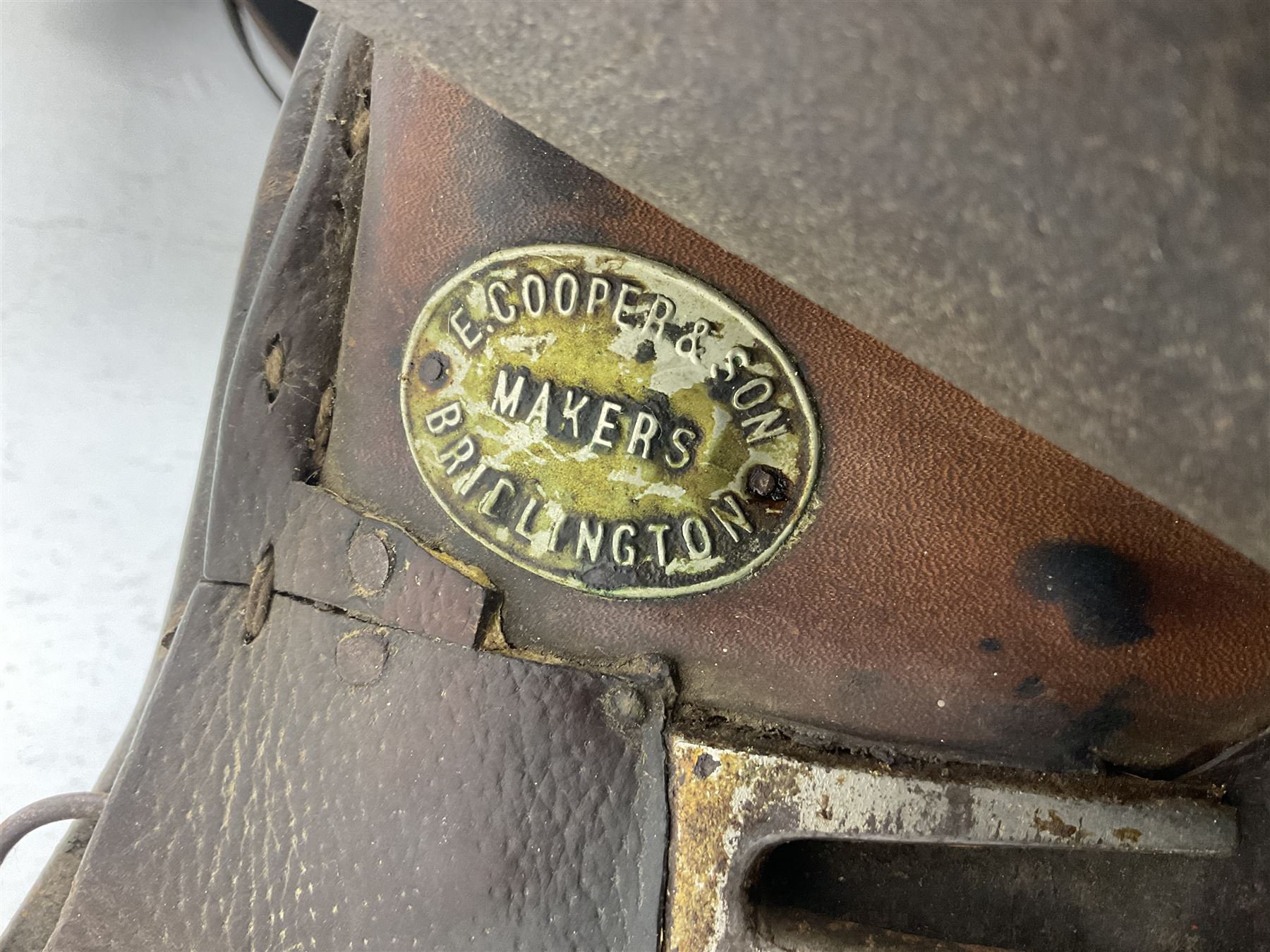 Collection of nine saddles, mainly havana leather to include a racing saddle and a Goodwin saddle, some with stirrups and leathers 