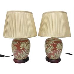 Pair of lamps of baluster form, decorated with daffodils upon a red ground,  raised upon circular base, including shades H52cm