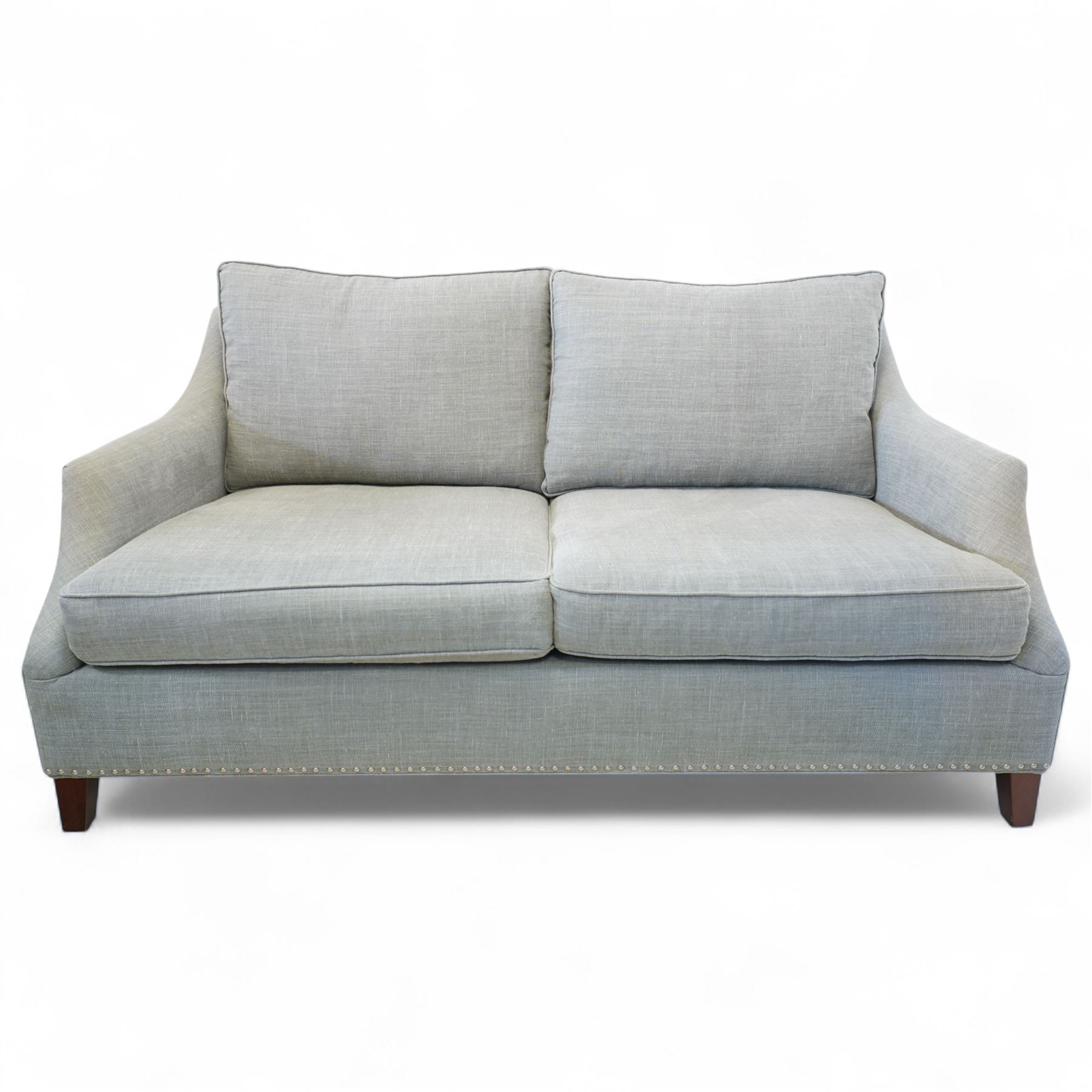 Neptune traditional style two-seat sofa, sloped back rest, gently flared arms, studded upholstered in a light grey fabric on square tapered legs 