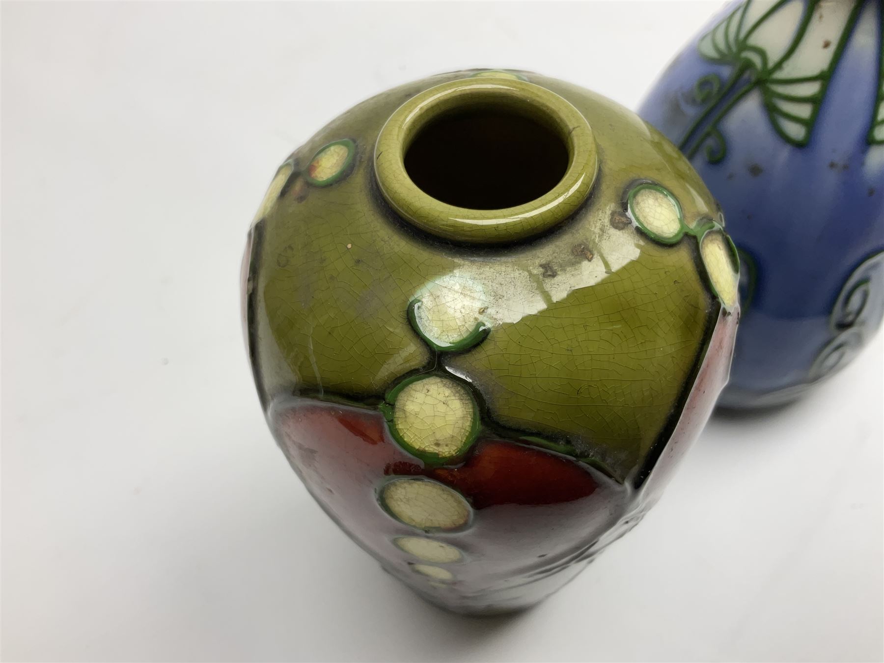 Minton Secessionist vase, with tube-lined stylised flower head decoration on a blue ground, printed mark to base 'Minton Ltd, No. 30', together with another Minton Secessionist tubelined vase,  printed mark to base 'Minton Ltd, No. 16', tallest example H13.5cm