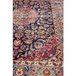 Vintage Persian Tabriz indigo ground rug, the central floral medallion within a field woven with scrolling palmettes and plant motifs, with contrasting spandrels, the the cyan guard lines with scrolling floral patterns