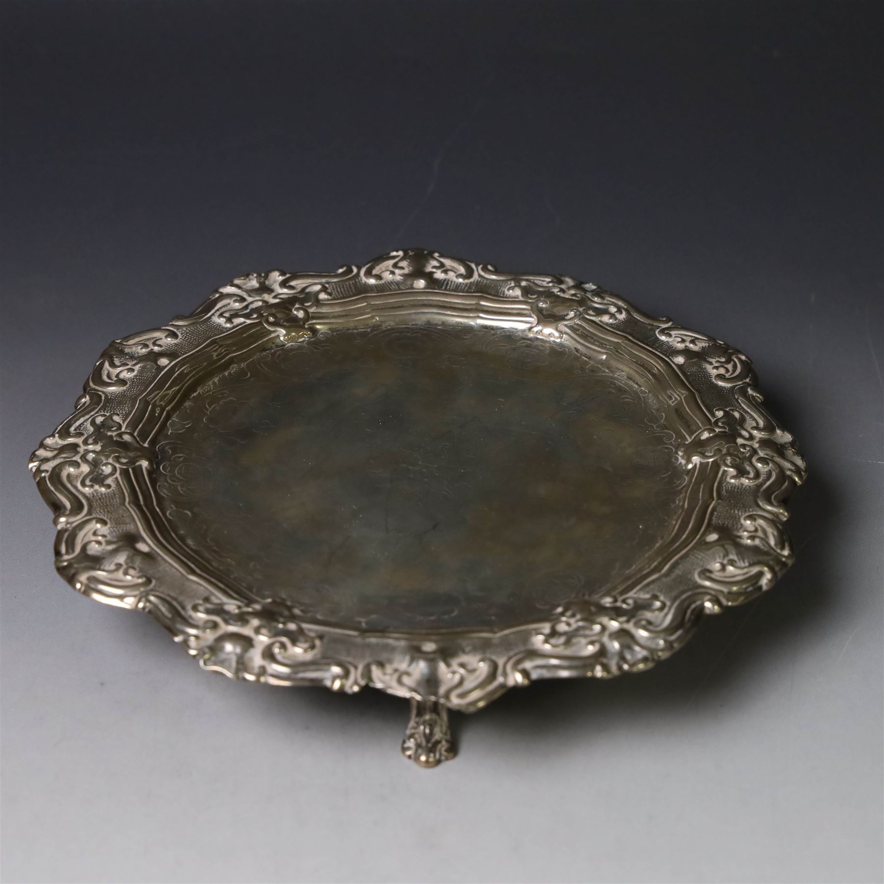 19th century continental silver waiter, of hexagonal form with stipple and scroll border, engraved with floral decoration to centre, upon three stylised paw feet, W19.2cm