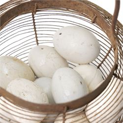Wire crock containing 11 broody hen ceramic dummy eggs, two marked 'Caperns' 