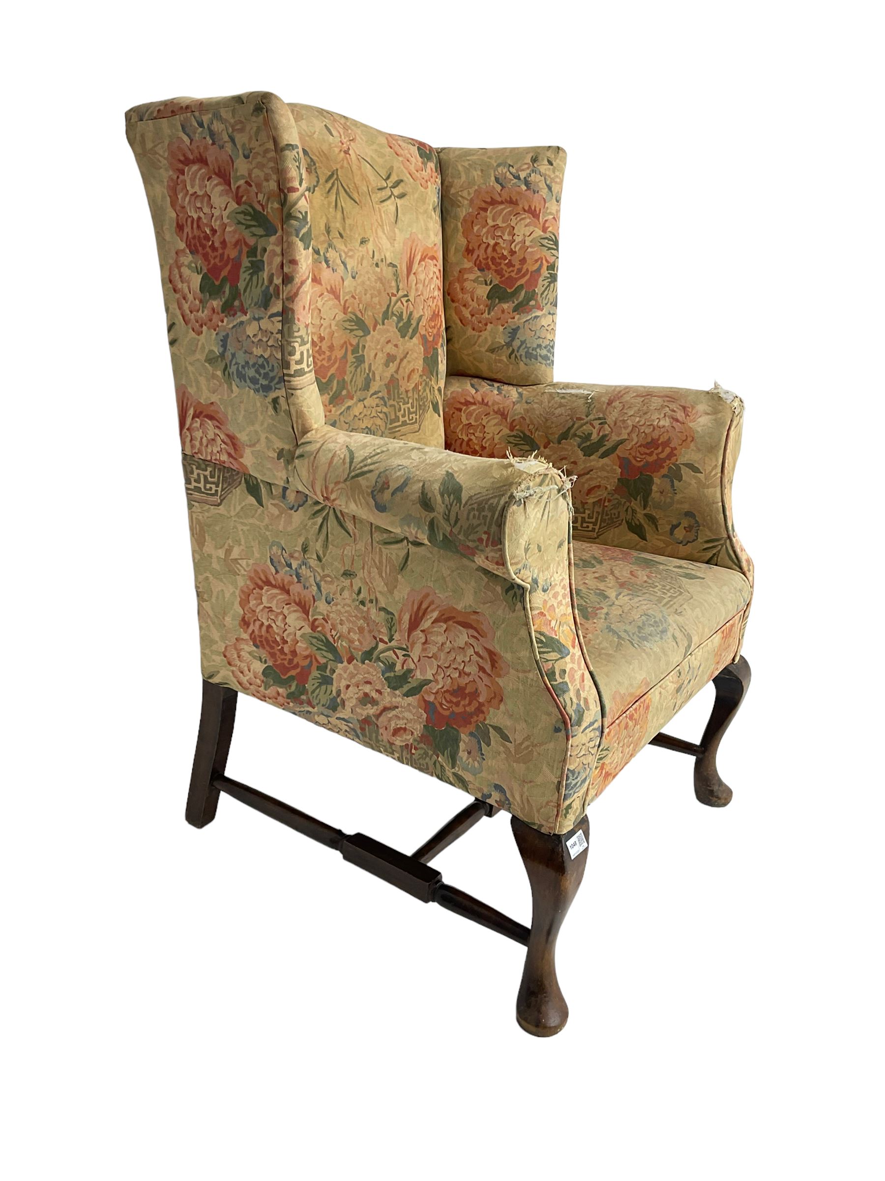Early 20th century Georgian style wingback armchair, upholstered in floral fabric with sprung seat, walnut frame with front cabriole supports