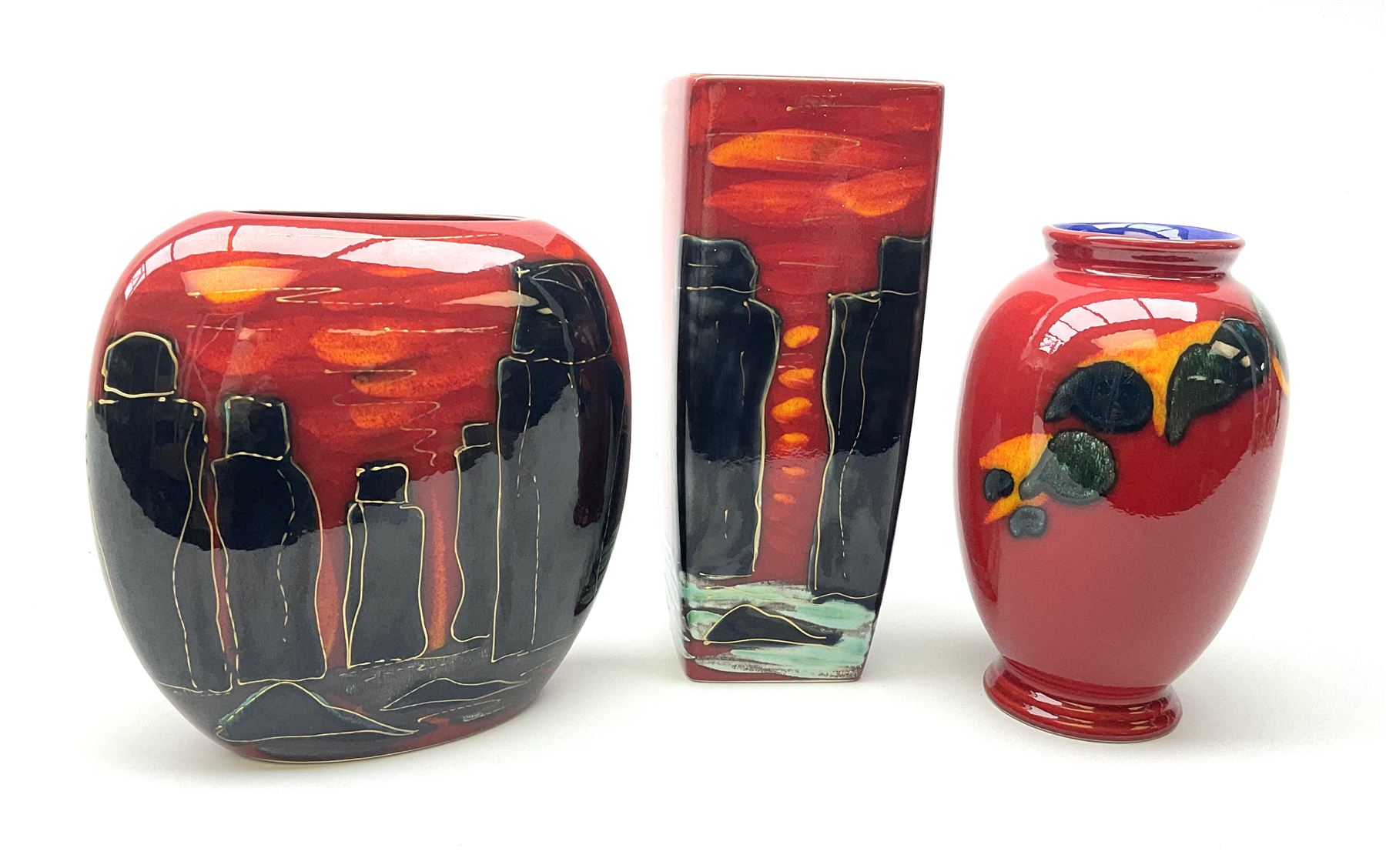 A Poole Pottery vase, of ovoid form decorated with green and yellow forms upon a red glazed ground, H20cm, together with two Anita Harris Art Pottery vase, with similar decoration. 