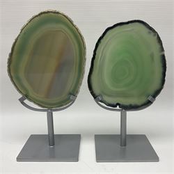 Pair of green agate slices, polished with rough edges raised upon silvered metal stands, H19cm