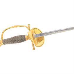 British Victorian court sword, for members of the Royal Household, by W.K & C of Solingen and retailed by Besch of Hanover St London, the 80cm blade etched to both side, the single bar hilt of gilt brass with Queens' crown pommel and downturned shell guard with the monogram of Queen Victoria, the wooden grip covered with silver wire, within leather scabbard with three gilt brass mounts and twin suspension rings, overall L96cm   
